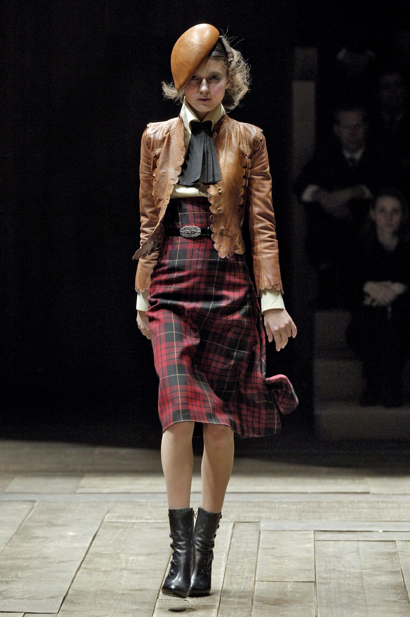 A high-waisted skirt with asymmetric draping in red and black wool tartan, from the Alexander McQueen Autumn/Winter 2006 collection.
